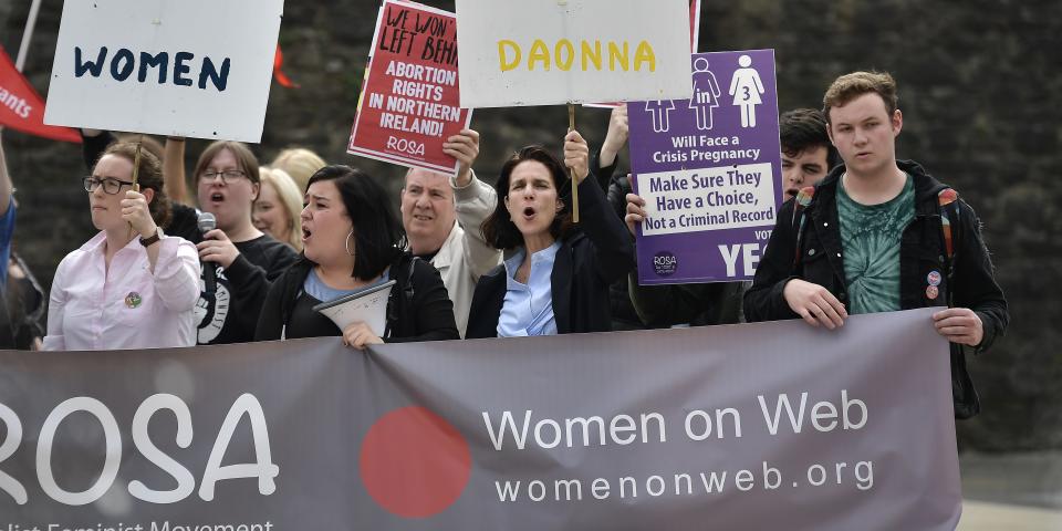 Rebecca Gomperts holds a sign during a protest.