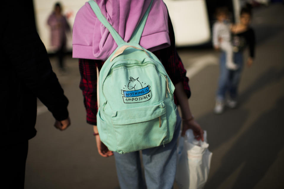 Violetta walks to take a bus after her arrival from Mariupol to a reception center for displaced people in Zaporizhzhia, Ukraine, Tuesday, May 3, 2022. Thousands of Ukrainian continue to leave Russian occupied areas. (AP Photo/Francisco Seco)