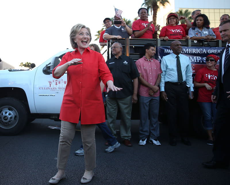 <p>On the campaign trail in Las Vegas, Hillary Clinton dressed down in a long-hemmed button-down shirt in bright red that she paired with khakis and ballet flats. (Photo: Joe Raedle/Getty Images) </p>