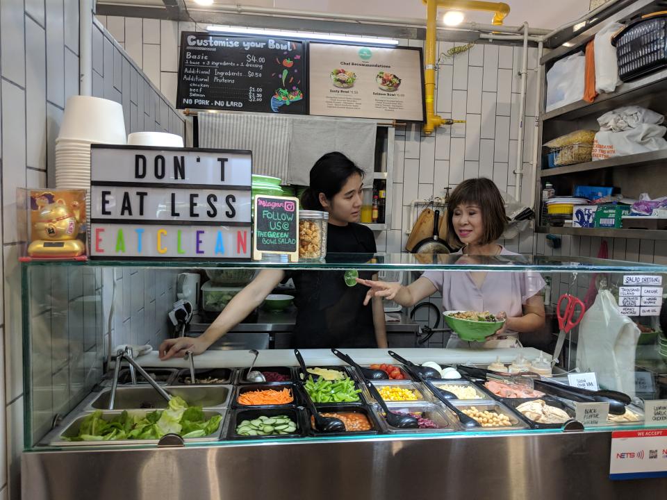 Poh Ying Min (left), owner of incubation stall The Green Bowl, speaking with <span>Senior Minister of State for the Environment and Water Amy Khor during her visit of Bukit Merah Food Central on 10 October, 2018.</span> (PHOTO: Wong Casandra/Yahoo News Singapore)