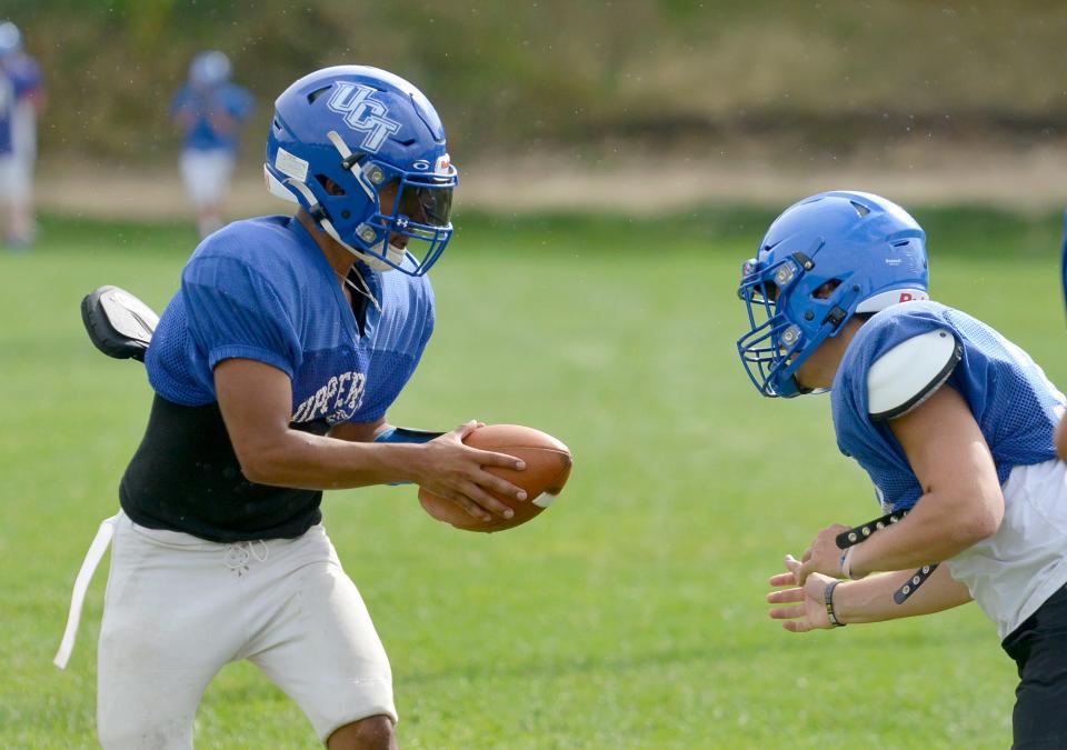 Upper Cape Tech's quarterback Jeshua Pandiscio, left, looks to pass the ball during a practice drill.