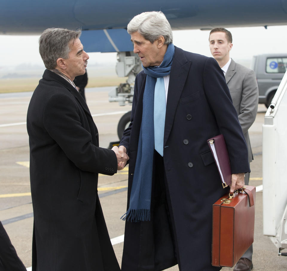 US Secretary of State John Kerry, right, is greeted on the tarmac upon his arrival in Paris, France, by Mark Taplin, left, who is the Charge d'Affaires at the US Embassy, Sunday, Jan. 12, 2014. US Secretary of State John Kerry is in Paris to attend a two-day meeting with other top national envoys aiming to bring Syria's main opposition group to attend face-to-face peace talks with the Syrian government. (AP Photo/Pablo Martinez Monsivais, Pool)