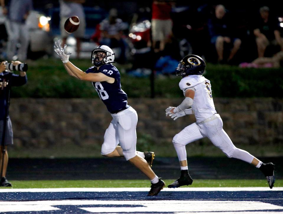 East Lansing's Charlie Baker, left, catches a pass for a touchdown against DeWitt's Abram Larner, Friday, Sept. 16, 2022, in East Lansing, Mich. East Lansing won 36-30.