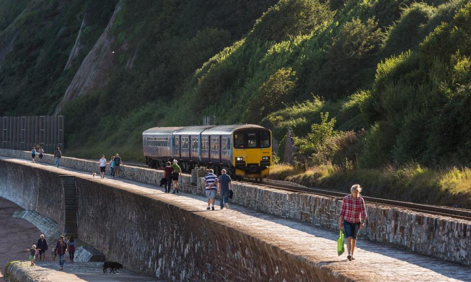<span>Some of the UK’s most spectacular walks can be done by plotting routes between stations. Pictured: the sea wall path at Teignmouth, Devon.</span><span>Photograph: Montacute/Alamy</span>