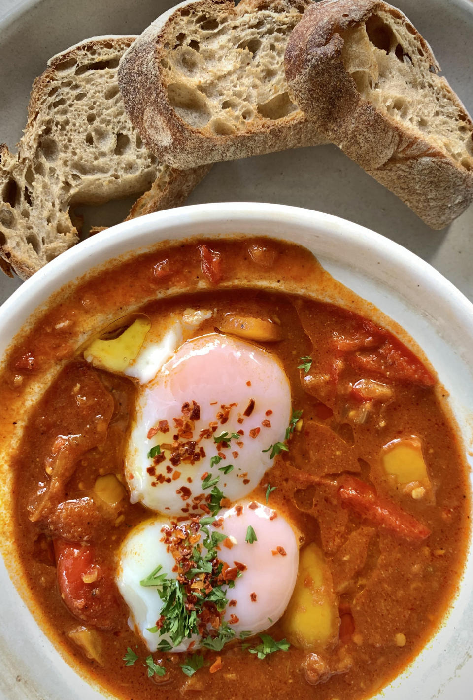 a bowl of tomato sauce with eggs on top