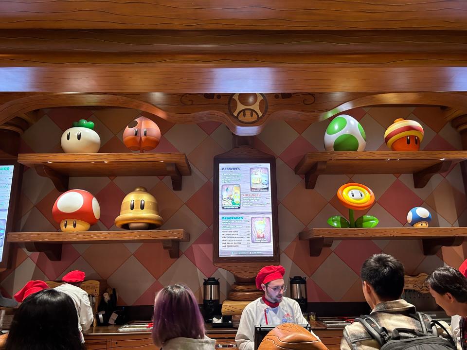 Ordering area at Toadstool Cafe has ordering screens and iconic Super Mario symbols, including Super Mushroom and Power Flower