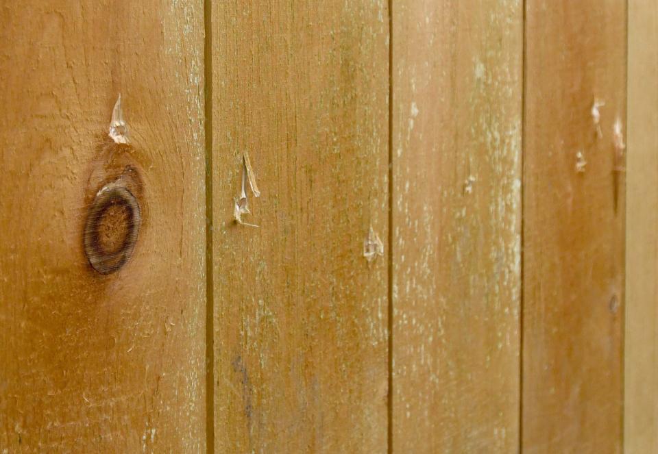 Bullet holes are seen in the wooden security fence at the home of James Williams, who was shot to death by a Canton police officer last year.