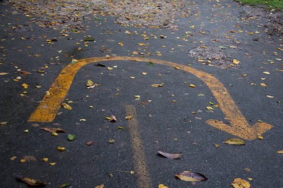 A U-turn sign painted on the pavement.