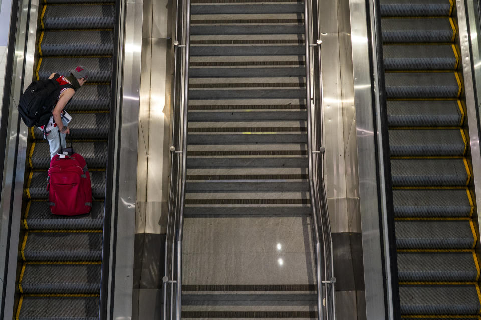 A passenger makes his way through Johannesburg's OR Tambo's airport Monday Nov. 29, 2021. The World Health Organisation urged countries around the world not to impose flight bans on southern African nations due to concern over the new omicron variant. (AP Photo/Jerome Delay)