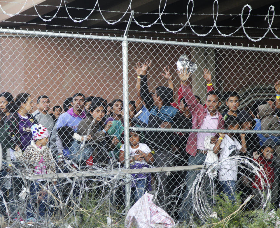 FILE--In this March 27, 2019, file photo, Central American migrants wait for food in a pen erected by U.S. Customs and Border Protection to process a surge of migrant families and unaccompanied minors in El Paso, Texas. The U.S. government is working to open two new large tent facilities to temporarily detain up to 1,000 migrant parents and children near the southern border. U.S. Customs and Border Protection said in a notice to potential contractors that it's seeking to build large tents in El Paso, Texas, and in South Texas that could house 500 people at a time. The notice says families would sleep on mats inside each tent. (AP Photo/Cedar Attanasio, File)