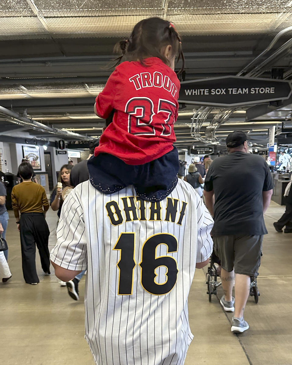A father carries his daughter on his shoulders through through the concourse of Guaranteed Rate Field during a baseball game between the Chicago White Sox and the Los Angeles Angels Wednesday, May 31, 2023, in Chicago. (AP Photo/Charles Rex Arbogast)
