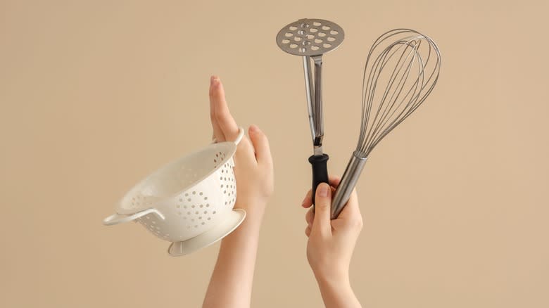 Hands holding cooking utensils