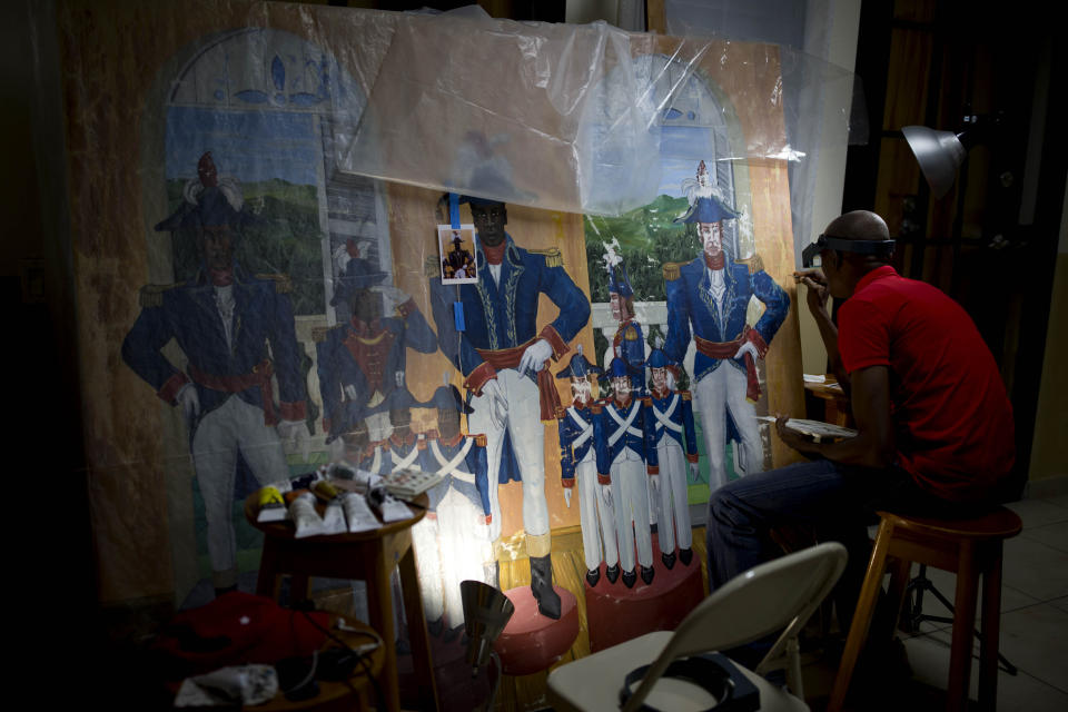 In this June 28, 2019 photo, Haitian artist Ernst Jeudy works on the restoration of a painting by Haitian artist Edouard Duval Carrie, at the Musée d'Art du Collège Saint Pierre, in Port-au-Prince, Haiti. It is one of dozens of well-known paintings that artists are still trying to rescue nearly a decade after the magnitude 7.0 quake that killed an estimated 300,000 people or more and damaged countless buildings, including the Museum of Haitian Art of St. Pierre College, one of the country's top museums. (AP Photo/Dieu Nalio Chery)