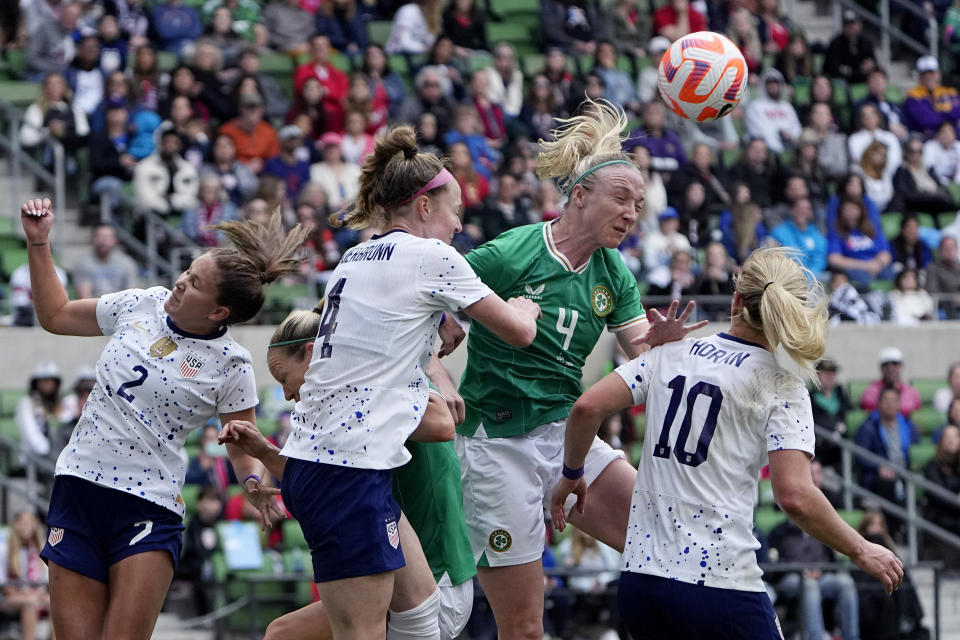 Ireland defender Louise Quinn, center, heads the ball away from United States midfielder Ashley Sanchez (2) and defender Becky Sauerbrunn (4) during the second half of an international friendly soccer match in Austin, Texas, Saturday, April 8, 2023. (AP Photo/Eric Gay)