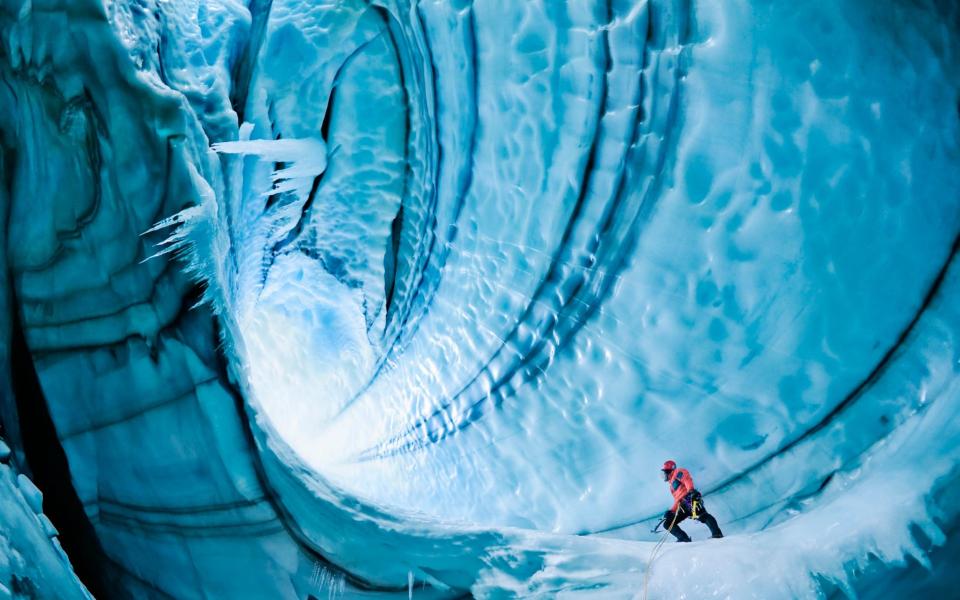 An ice climber exploring a cave in Langjokull Glacier, Iceland