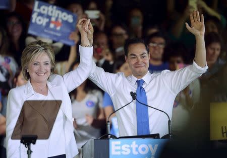 Democratic U.S. presidential candidate Hillary Clinton holds the hand of HUD Secretary Julian Castro after he endorsed her at a "Latinos for Hillary" rally in San Antonio, Texas in this October 15, 2015, file photo. REUTERS/Darren Abate/Files