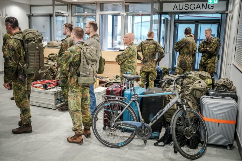 Bundeswehr soldiers from the pre-command of the Lithuanian brigade wait at the military section of Berlin-Brandenburg Airport for their departure to Vilnius with Airbus A400Ms next to their luggage. The Lithuanian brigade is expected to be operational by the end of 2027 with around 4800 soldiers. Kay Nietfeld/dpa