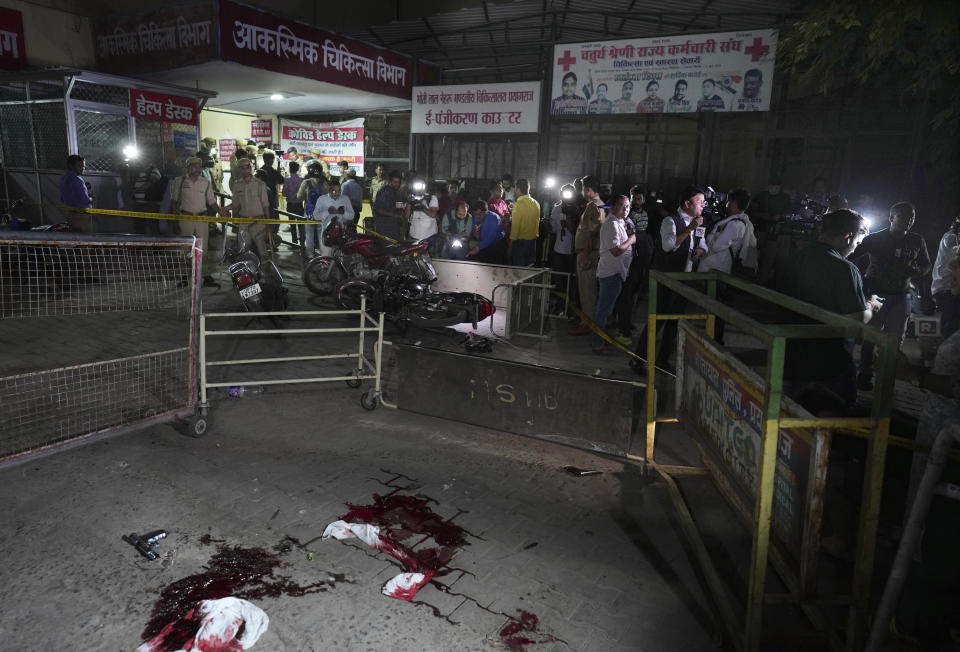 A pistol and blood soaked scarfs of Gangster-turned-politician Atiq Ahmad and his brother Ashraf lie in front of the Motilal Nehru medical college in, Prayagraj, India, Saturday, April 15, 2023. Jailed gangster-turned-politician Atiq Ahmad and his brother Ashraf were shot dead by unidentified assailants while they were being escorted by police to a medical college here on Saturday night, according to the Indian news agency Press Trust of India. (AP Photo/Rajesh Kumar Singh)