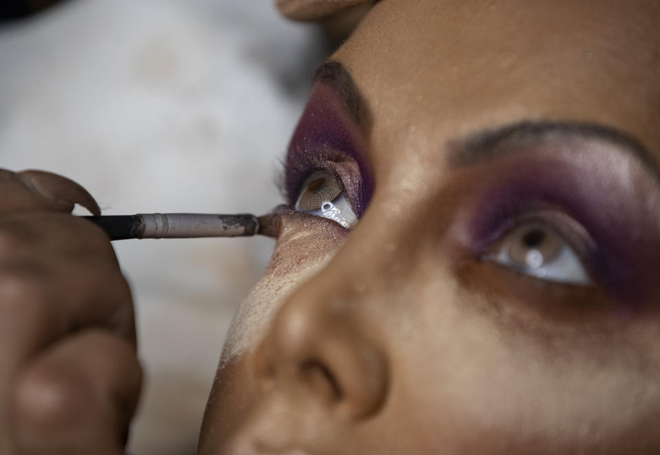 Transgender godmother Camila Prins gets her make up done prior to performing for Colorado do Bras samba school in Sao Paulo, Brazil, Saturday, Feb. 22, 2020. At a Carnival party in Sao Paulo state when just 11 years of age, Prins had her first realization she wanted to be a woman, when, like the other boys, she was finally allowed to dress like a girl as part of the burlesque festivities. On Saturday, she became the first transgender woman to lead the drum section of a top samba school in either Sao Paulo or Rio de Janeiro's world famous parades. (AP Photo/Andre Penner)