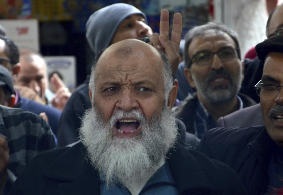 Supporters of the Tunisian Islamist movement Ennahda stage a protest in front of the justice ministry to denounce the arrest one of its senior leader in Tunis, Tunisia, Friday, Dec. 23, 2022. The protesters denounced the arrest of one of its senior leaders, suspected of being involved in sending Tunisians to fight with extremists in Syria. (AP Photo/Hassene Dridi)