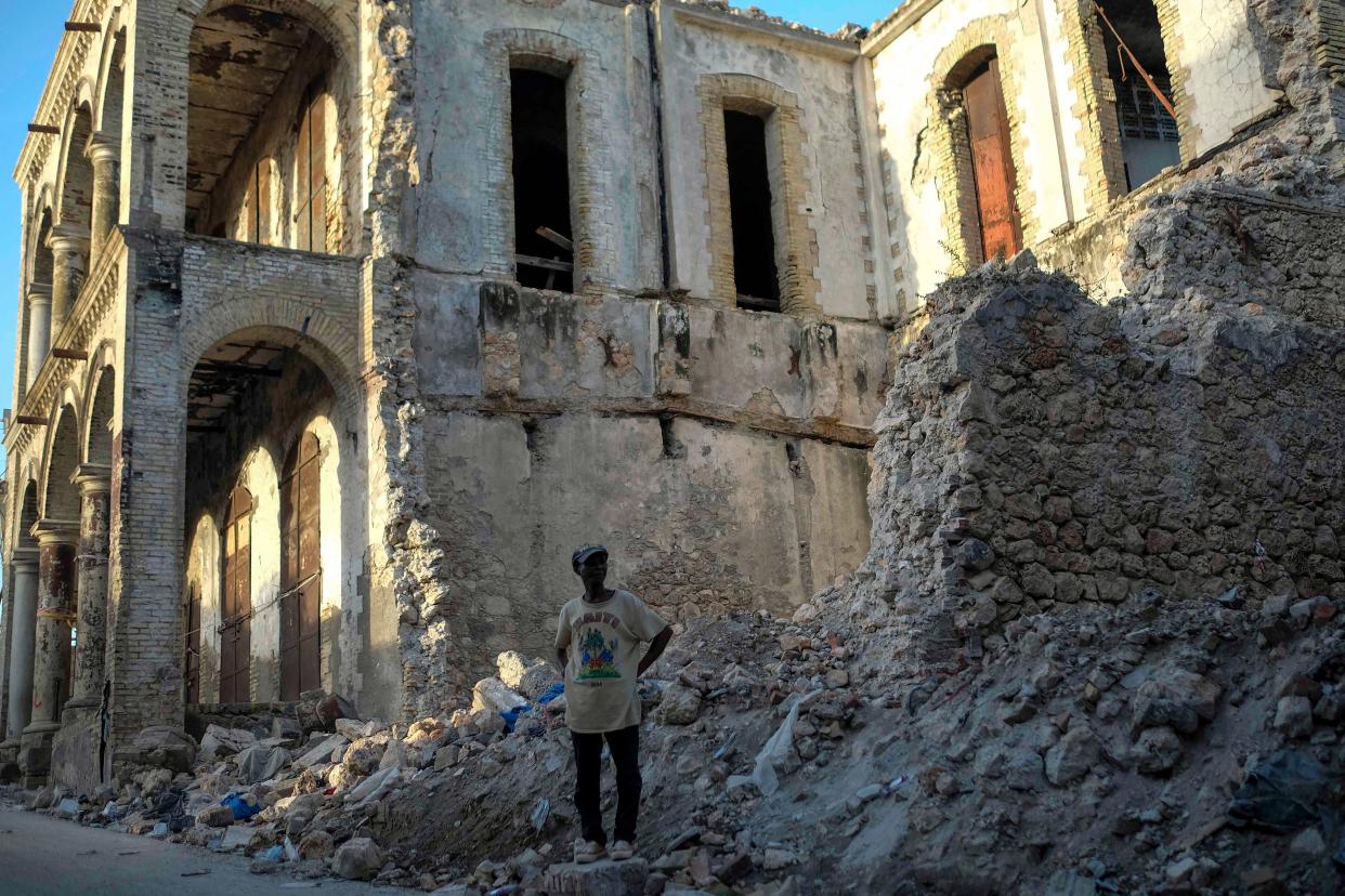 A man stands close to the rubble of a collapsed building in Jeremie, Haiti, Wednesday, Aug. 18, 2021, four days after the city was struck by a 7.2-magnitude earthquake.