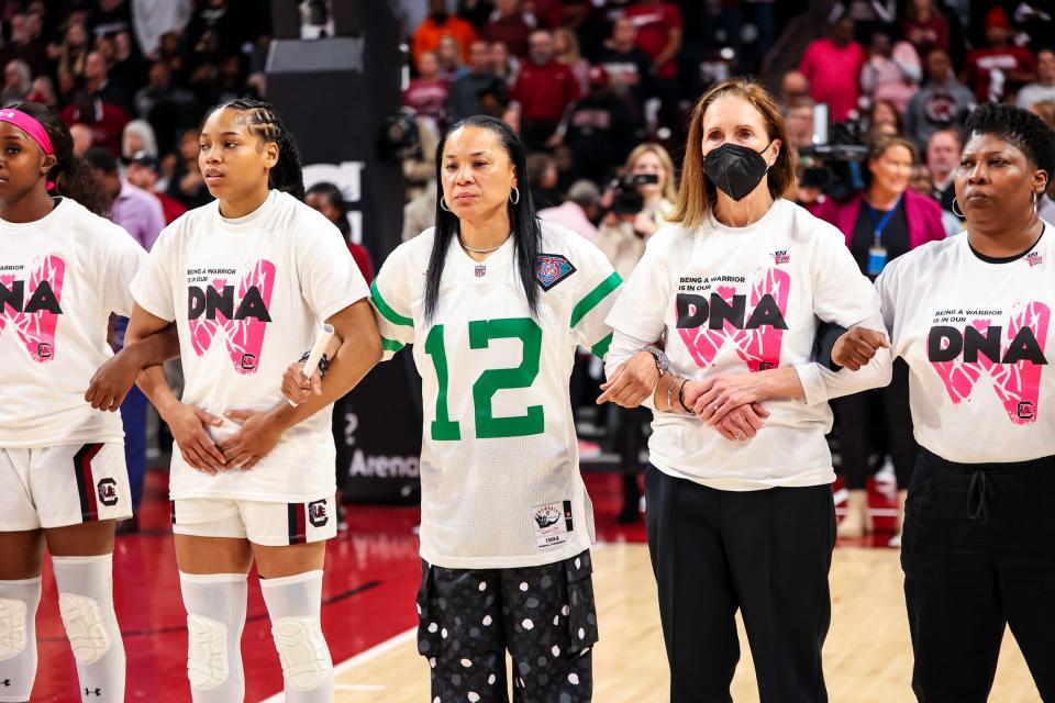 South Carolina women's basketball coach Dawn Staley (center) in her Randall Cunningham vintage jersey Sunday.