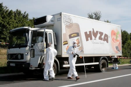 FILE PHOTO: Forensic police officers inspect a parked truck in which up to 50 migrants were found dead on a motorway near Parndorf