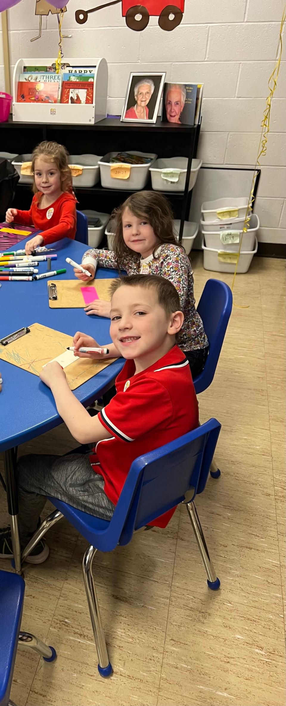 A-C Elementary School kindergartners Hannah Willis, Charlotte Rothe and Brooks Wessel, top to bottom, make bookmarks at the dedication of 'Dot's Story Corner' at the school on March 26, 2024. Books were donated to kindergarten classes in the name of Dorothy 'Dot' Newell.