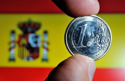 A euro coin with the Spanish national flag in the background. Spain battled to contain fears of financial collapse Wednesday, scrambling to fund a major banking rescue as its debt risk premium rocketed to a euro-era record