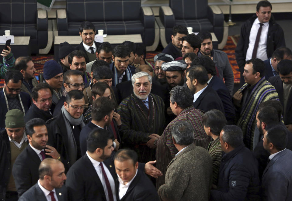Afghanistan Chief Executive Abdullah Abdullah, center, shakes hands with his supporters after arriving to register as a candidate for the presidential election, at the Independent Elections Commission, in Kabul, Afghanistan, Sunday, Jan. 20, 2019. President Ashraf Ghani and Abdullah on Sunday registered to run for president later this year, setting up a rematch after a bitterly disputed 2014 vote led to a power-sharing agreement brokered by the United States. (AP Photo/Rahmat Gul)