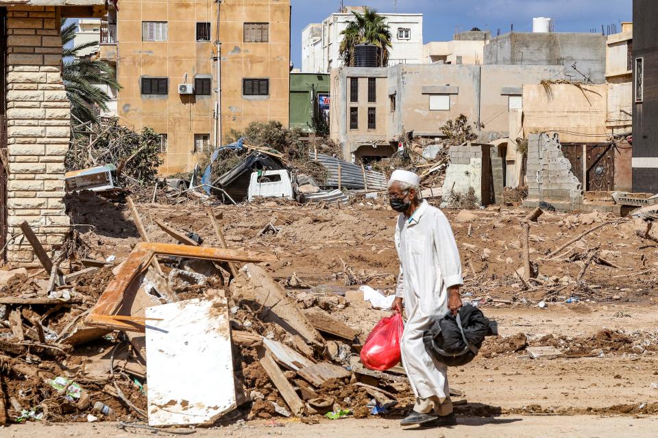 A man walks past the rubble of a destroyed building in Libya's eastern city of Derna, Sept. 18, 2023, following deadly flash floods. / Credit: MAHMUD TURKIA/AFP/Getty