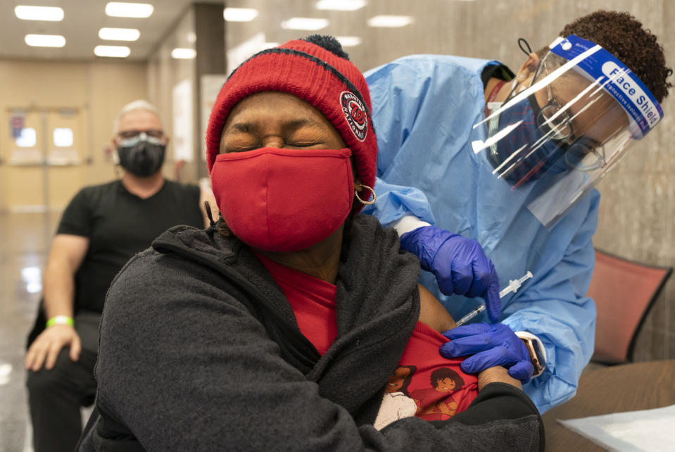 In this Thursday, Feb. 11, 2021, photo Jorie Winbish, 56, of Washington, reacts as she receives her second dose of the COVID-19 vaccine at a clinic at Howard University, in Washington. "I feel so lucky to have number two in my arm," says Winbish. (AP Photo/Jacquelyn Martin)