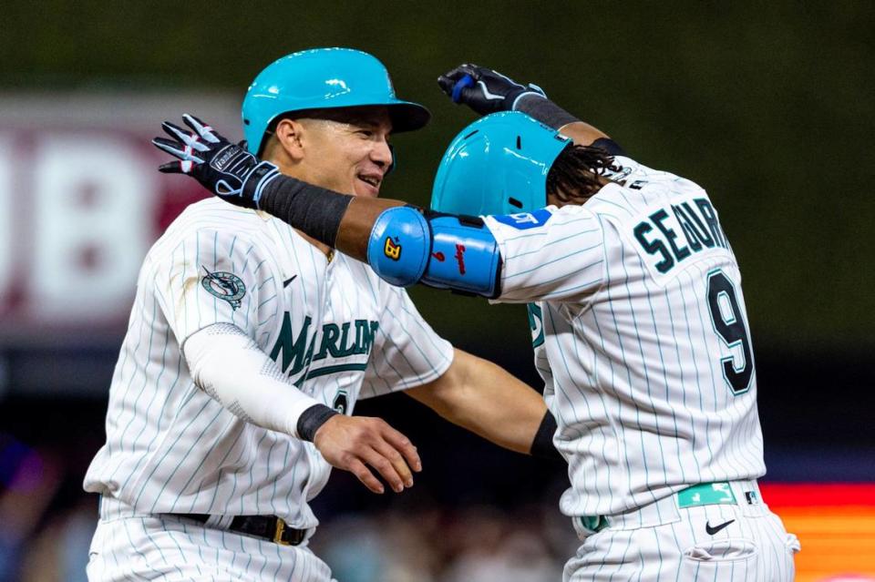 Miami Marlins batter Jean Segura (9) is embraced by teammate Avisail Garcia (24) after hitting a walk-off single during the ninth inning of an MLB game against the Chicago Cubs at loanDepot Park, in Miami, Florida, on Friday, April 28, 2023. The Marlins won 3-2 over the Cubs.