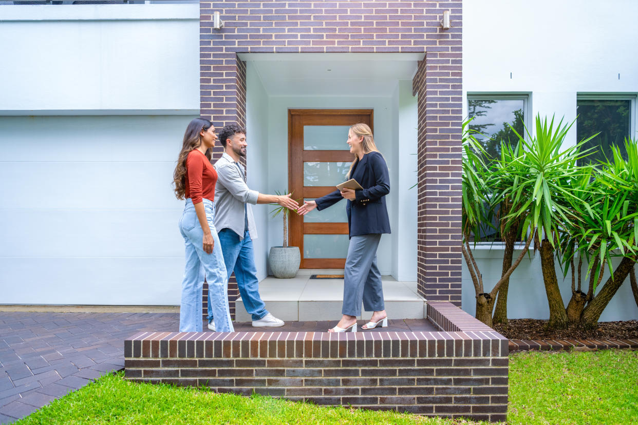 Real estate agent showing a couple a new house. (Credit: Getty Creative)