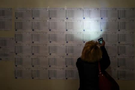 A woman uses her mobile phone to read voters list during a parliamentary election at a poling station in Yerevan, Armenia, April 2, 2017. Vahan Stepanyan/PAN Photo/Handout via REUTERS