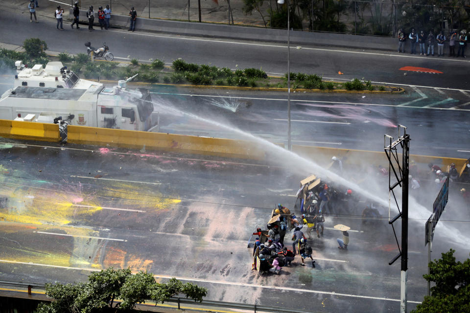 <p>Opposition supporters clash with riot security forces while rallying against President Nicolas Maduro in Caracas, Venezuela, May 18, 2017. (Christian Veron/Reuters) </p>