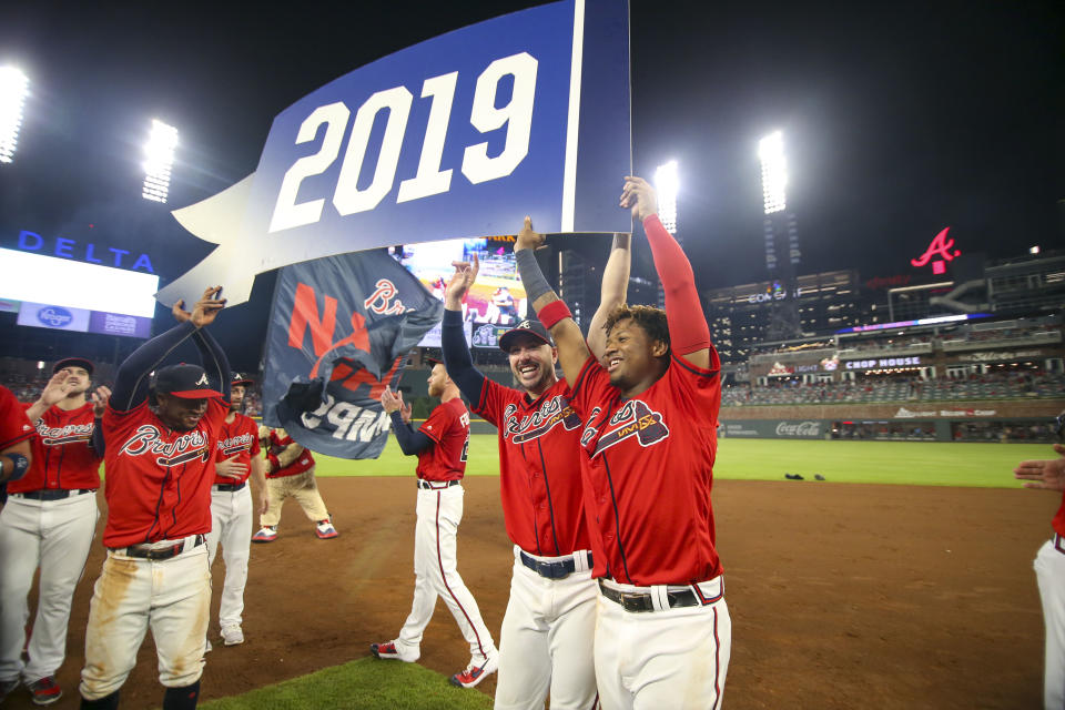 Atlanta Braves second baseman Ozzie Albies (1) and right fielder Matt Joyce (14) and center fielder Ronald Acuna Jr. (13) hold up the pennant after clinching the NL East division title on Sep 20, 2019 in Atlanta, Georiga. (Brett Davis-USA TODAY Sports)