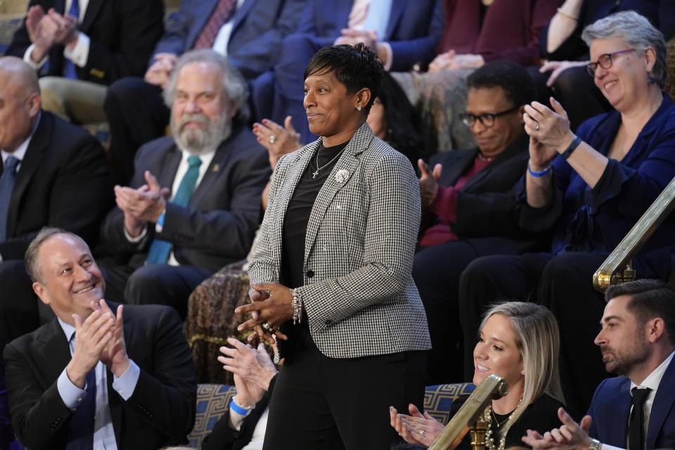 Saria Gwin-Maye, of Cincinnati, stands as she is recognized by President Joe Biden during the State of the Union address to a joint session of Congress at the U.S. Capitol, Tuesday, Feb. 7, 2023, in Washington. Doug Emhoff, husband of Vice President Kamala Harris, applauds at left. (AP Photo/Patrick Semansky)