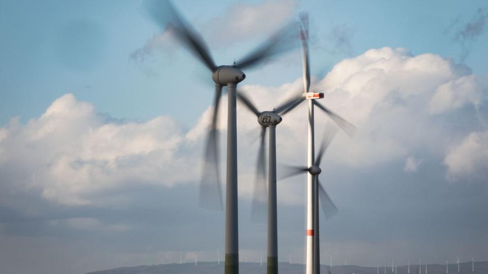 Windräder drehen sich auf einer Anhöhe in Rheinhessen.