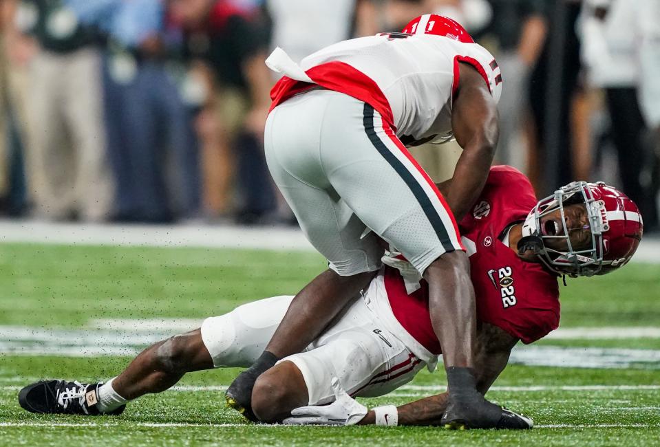 Alabama receiver Jameson Williams holds his knee after suffering an injury during the national title game.