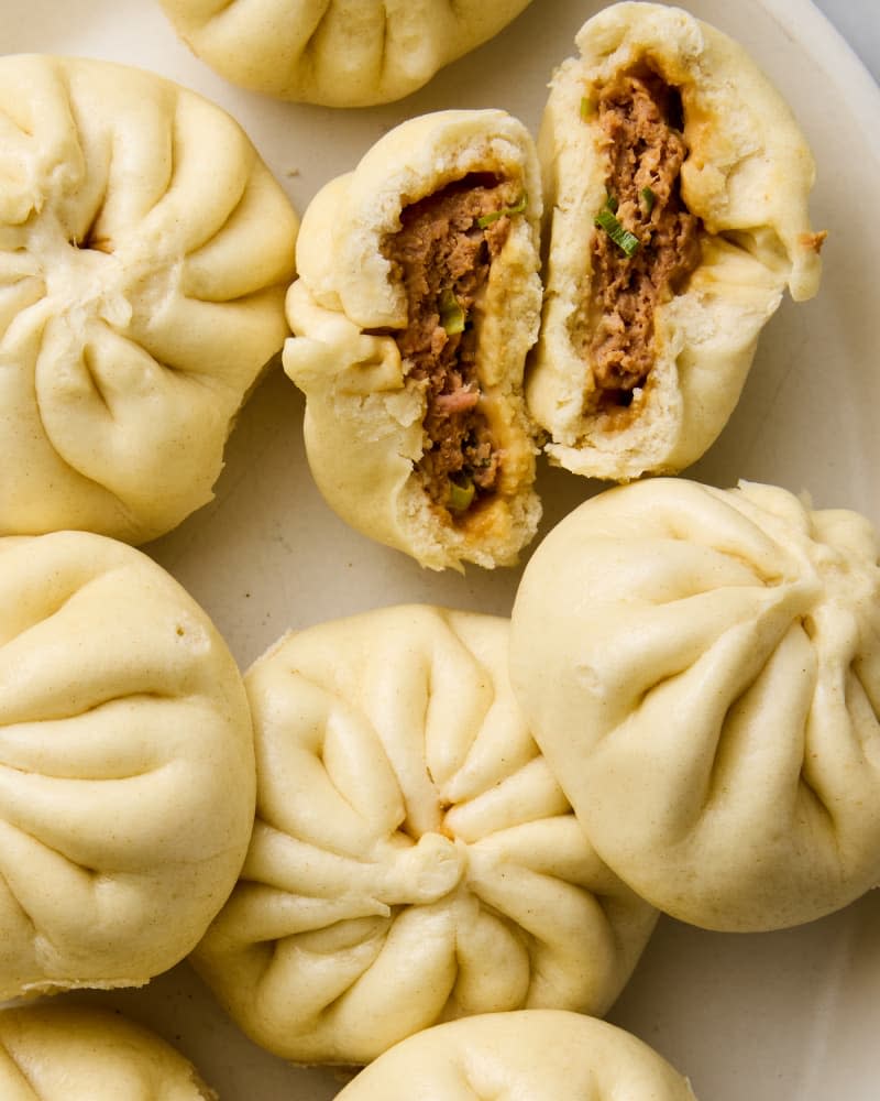 steamed buns on surface with one split open