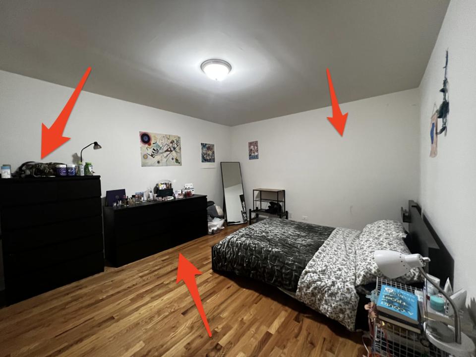 Bedroom with matching black furniture and posters on the wall.