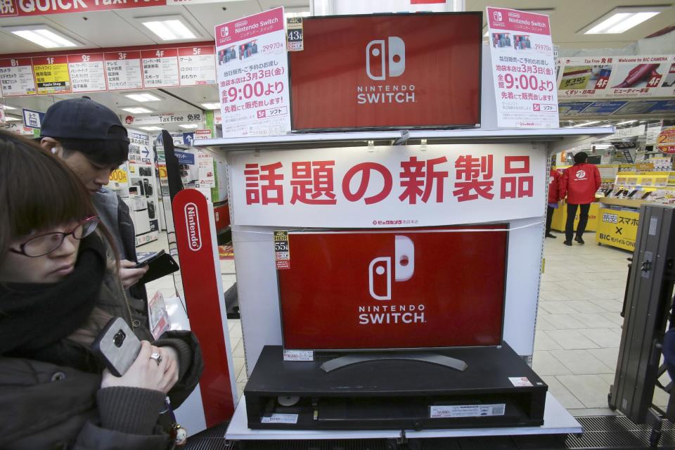 Shoppers wait at outside retail store Bic Camera to buy Nintendo's newest computer game "Switch" in central Tokyo, Friday, March 3, 2017. (AP Photo/Koji Sasahara)