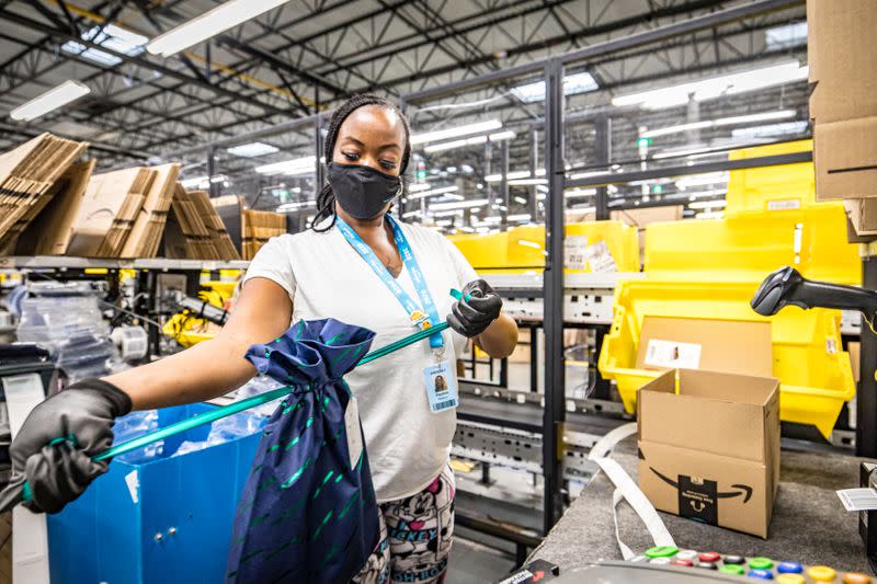 An Amazon.com Inc worker prepares an order in which the buyer asked for an item to be gift wrapped at a fulfillment center in Shakopee