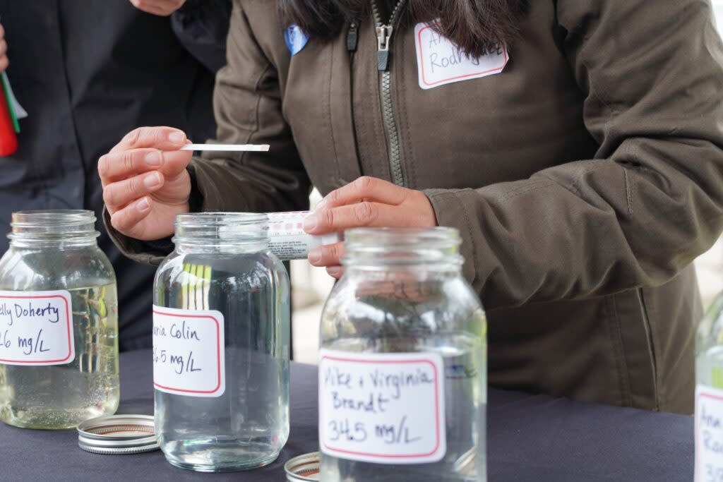 Ana Maria Rodriguez, an organizer with Oregon Rural Action, tests water brought from taps in Boardman. (Julia Shumway/Oregon Capital Chronicle)