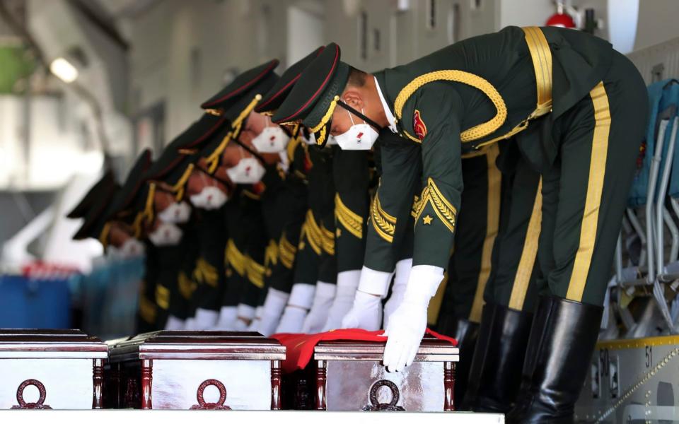 Chinese honor guard members put caskets containing the remains of Chinese soldiers in a cargo airplane during the handing over ceremony - South Korea Defense Ministry