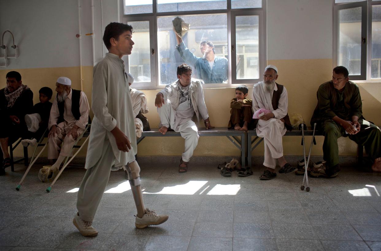 In this Monday, May 28, 2012 photo, Afghan polio patient Surat, 14, tries to learn how to walk with his new prosthetic at the ICRC physical rehabilitation center in Kabul, Afghanistan. 