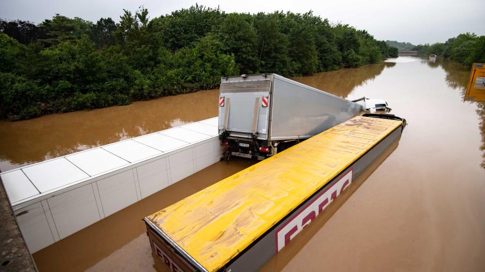 Drei Lastwagen stehen auf der überfluteten Bundesstraße 265 im tiefen Wasser und sind kaum mehr zu erkennen.