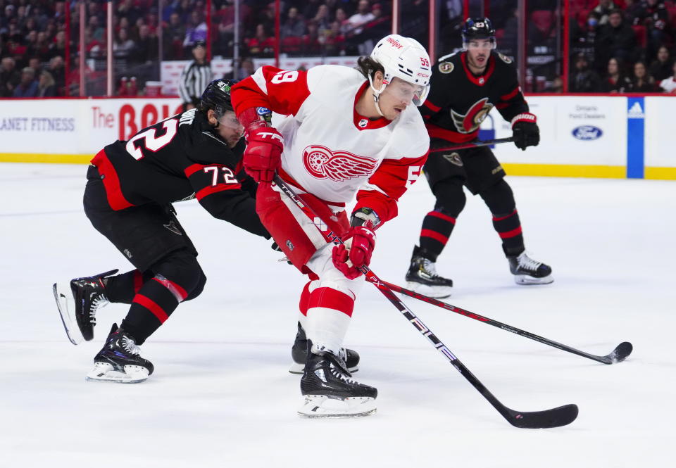 Detroit Red Wings left wing Tyler Bertuzzi (59) skates with the puck toward the net as Ottawa Senators defenseman Thomas Chabot (72) tries to push him off it during first-period NHL hockey game action in Ottawa, Ontario, Monday, Feb. 27, 2023. (Sean Kilpatrick/The Canadian Press via AP)