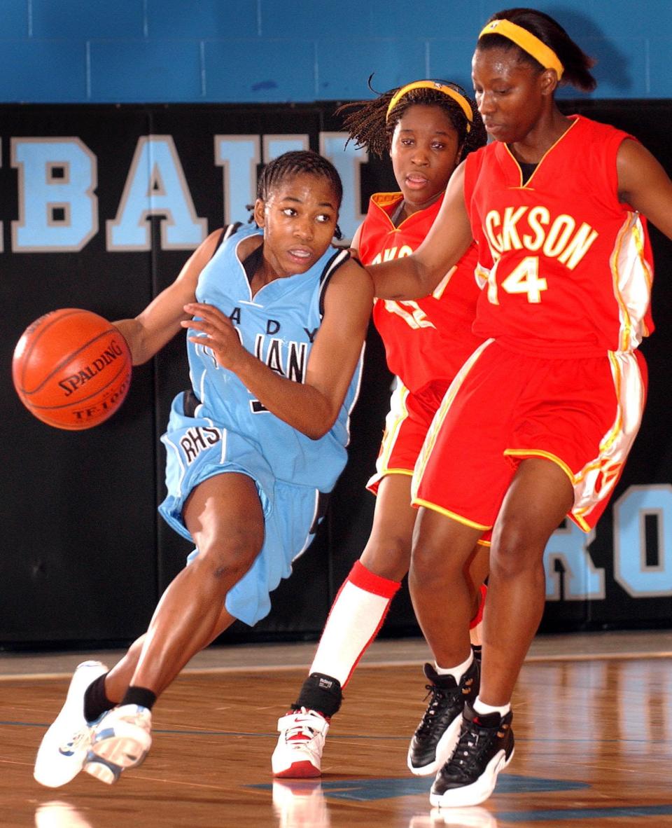 Ribault's Erica White, left, drives down the court past Jackson's Cerita Smith (14) and Brenda Harris (12) during the District 4-5A girls basketball championship.